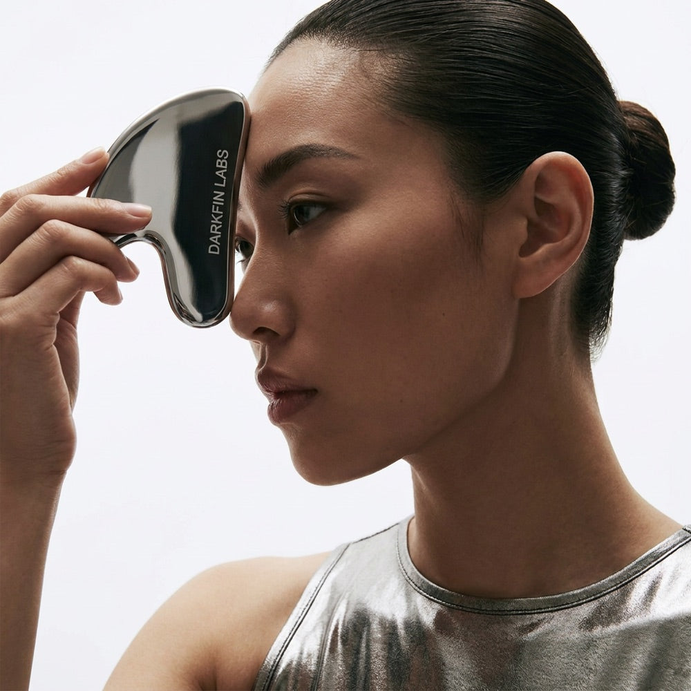 Sweeping the gua sha up and out across the brow