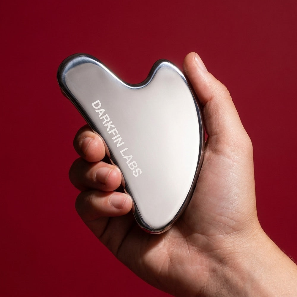 The gua sha held in a hand, for scale